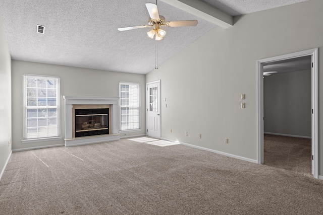 unfurnished living room featuring carpet, a premium fireplace, lofted ceiling with beams, and plenty of natural light