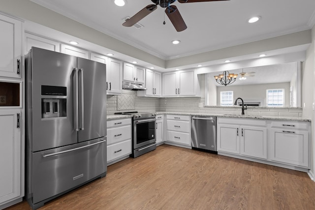 kitchen with appliances with stainless steel finishes, light wood-style floors, white cabinetry, a sink, and under cabinet range hood