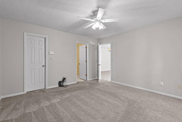 carpeted empty room featuring ceiling fan, baseboards, and a textured ceiling