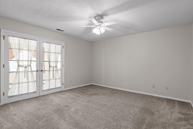 empty room featuring visible vents, ceiling fan, a textured ceiling, french doors, and carpet floors