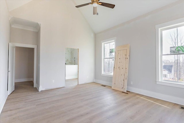 unfurnished room with ceiling fan, ornamental molding, high vaulted ceiling, and light wood-type flooring