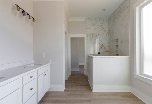 bathroom with hardwood / wood-style flooring, vanity, and ornamental molding