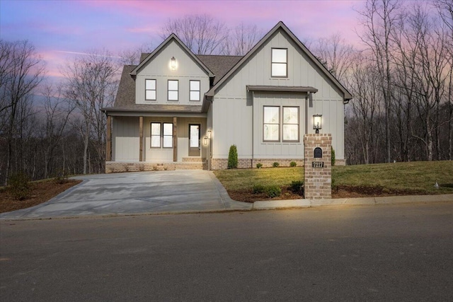 modern farmhouse style home with a yard, board and batten siding, and a shingled roof