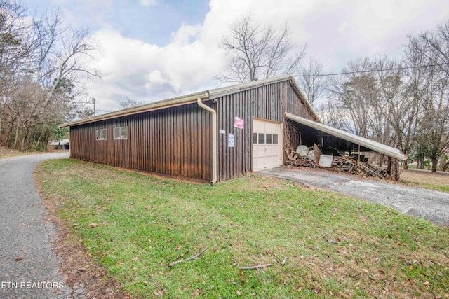 view of side of property featuring a garage and a lawn