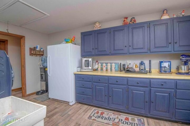 kitchen with washer / clothes dryer, blue cabinets, white refrigerator, and light hardwood / wood-style floors