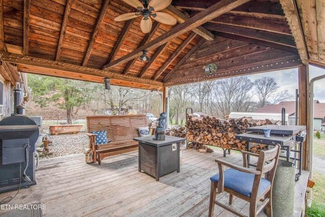 wooden terrace featuring ceiling fan, a gazebo, and grilling area