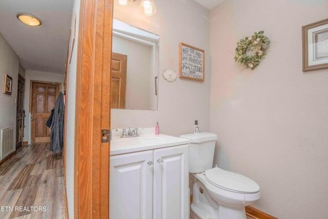 bathroom featuring toilet, hardwood / wood-style flooring, and vanity