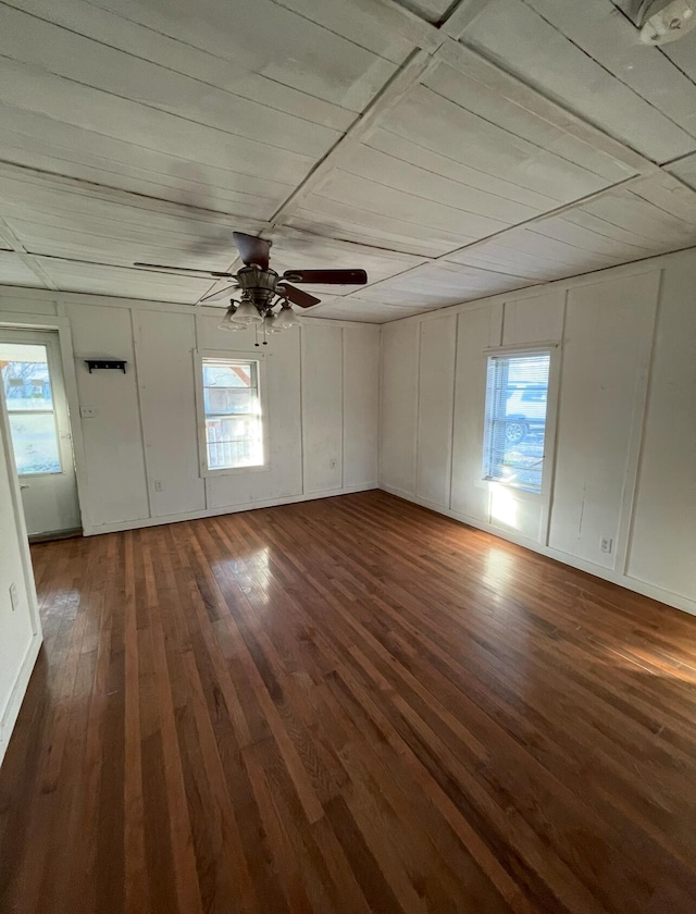 unfurnished room featuring ceiling fan, a healthy amount of sunlight, and dark hardwood / wood-style floors