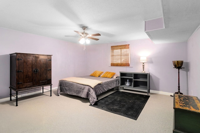 carpeted bedroom featuring ceiling fan and a textured ceiling