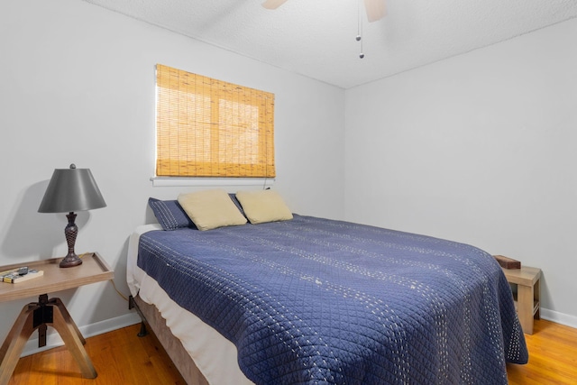 bedroom featuring hardwood / wood-style flooring, ceiling fan, and a textured ceiling