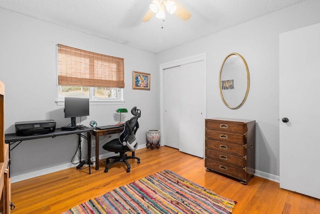 office space featuring a textured ceiling, ceiling fan, and light wood-type flooring