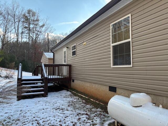 view of snow covered exterior with a wooden deck