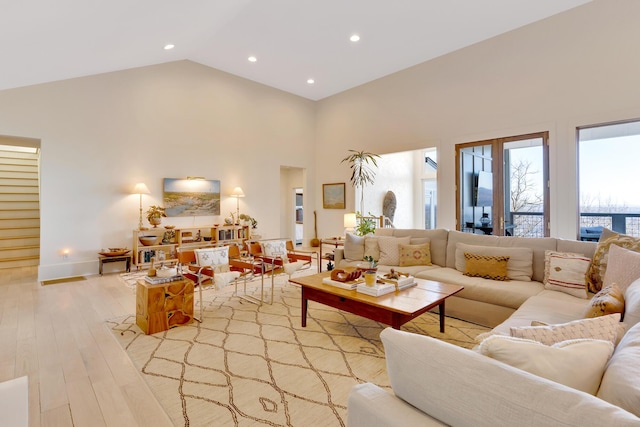 living room featuring light hardwood / wood-style flooring and high vaulted ceiling