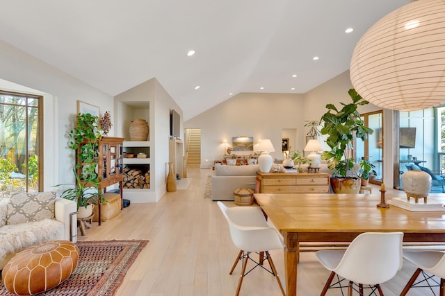 dining space featuring vaulted ceiling and light hardwood / wood-style floors