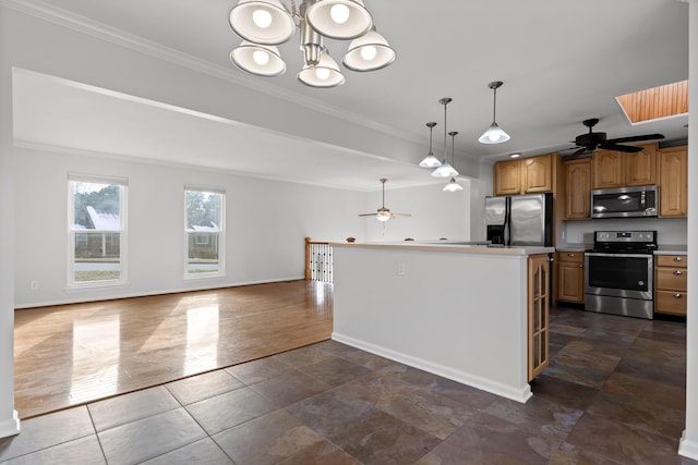 kitchen featuring appliances with stainless steel finishes, crown molding, ceiling fan with notable chandelier, and a kitchen island