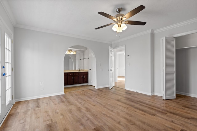 unfurnished bedroom with ceiling fan, a closet, crown molding, and light hardwood / wood-style floors