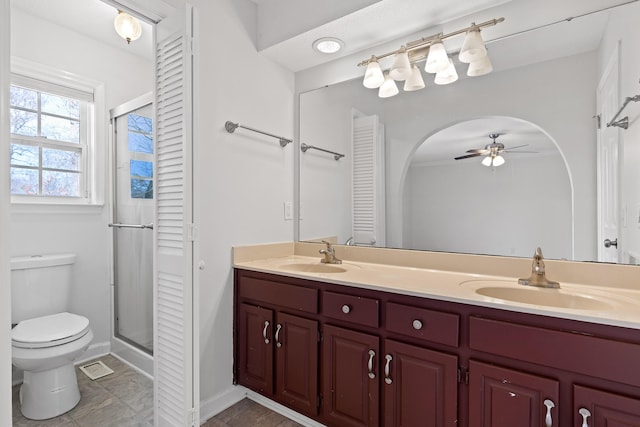 bathroom featuring ceiling fan, vanity, an enclosed shower, and toilet