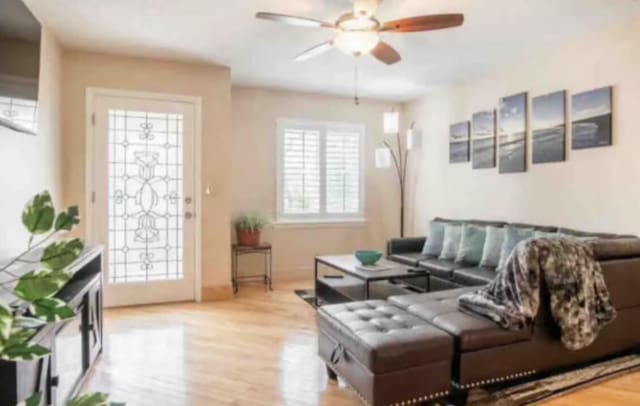 living room with light hardwood / wood-style floors and ceiling fan