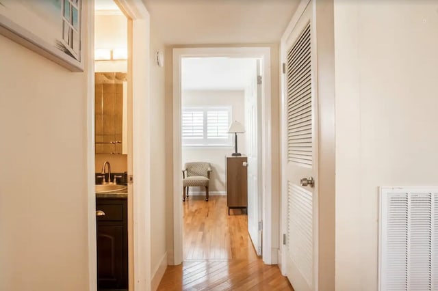 hall with sink and light hardwood / wood-style flooring