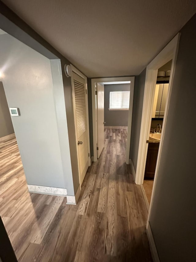 hall with hardwood / wood-style floors and sink