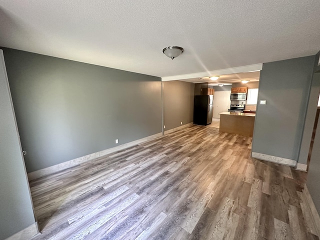 unfurnished living room with hardwood / wood-style floors and a textured ceiling