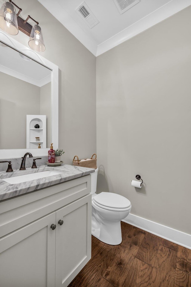 bathroom featuring crown molding, hardwood / wood-style floors, toilet, and vanity