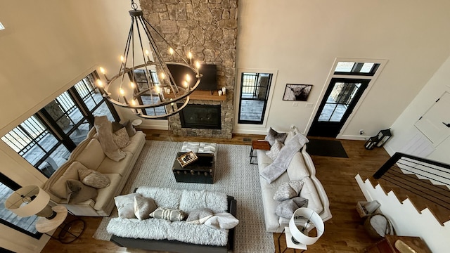 living room featuring a fireplace, plenty of natural light, a towering ceiling, and dark hardwood / wood-style floors