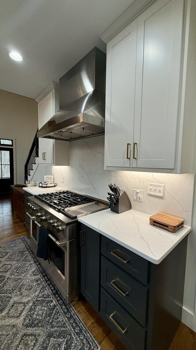 kitchen featuring wall chimney exhaust hood, white cabinetry, tasteful backsplash, double oven range, and dark hardwood / wood-style floors