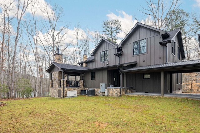 rear view of house with a yard and central AC unit