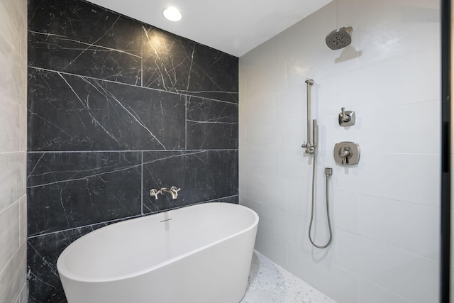 bathroom featuring separate shower and tub and tile walls