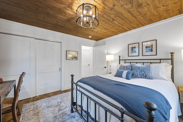 bedroom with wood ceiling, dark wood-type flooring, an inviting chandelier, and a closet