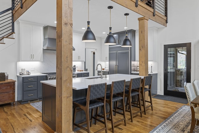 kitchen featuring sink, gray cabinetry, a kitchen breakfast bar, pendant lighting, and white cabinets