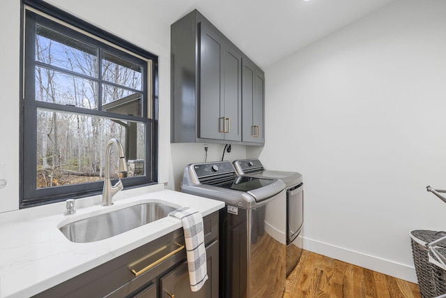 laundry room featuring separate washer and dryer, sink, dark hardwood / wood-style floors, and cabinets