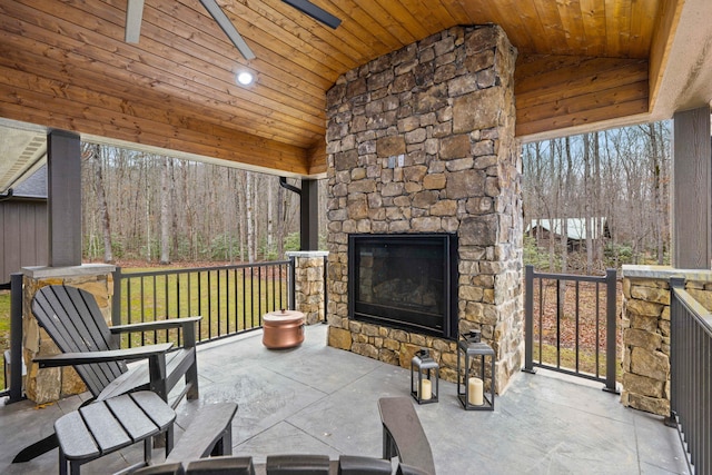 view of patio / terrace featuring ceiling fan and an outdoor stone fireplace