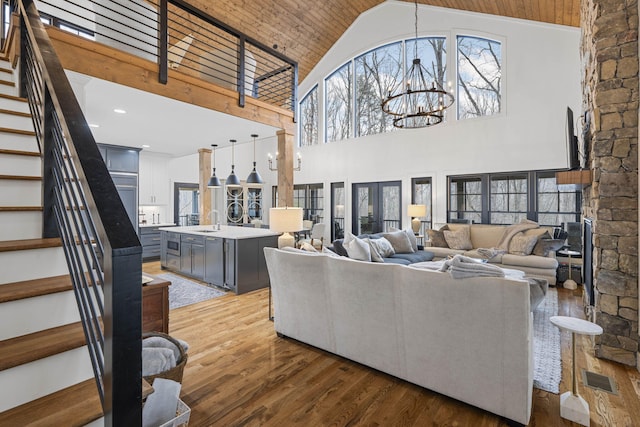 living room with high vaulted ceiling, dark hardwood / wood-style floors, sink, and a notable chandelier