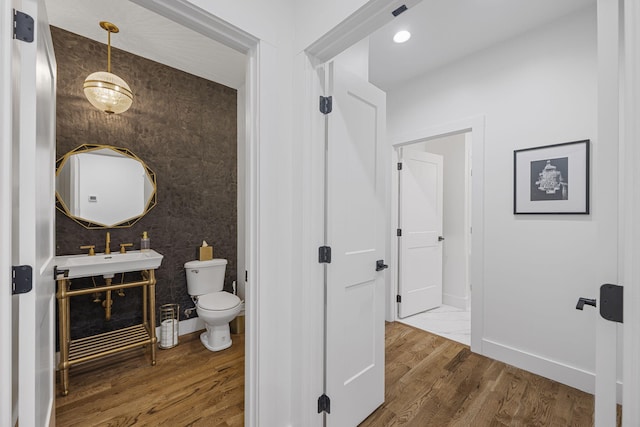 bathroom with sink, wood-type flooring, and toilet