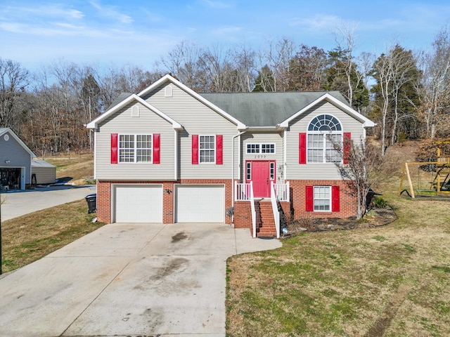 raised ranch featuring a garage and a front yard