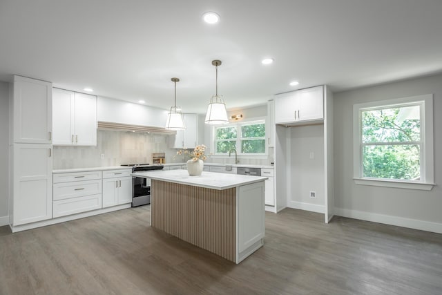 kitchen featuring a center island, stainless steel stove, decorative backsplash, white cabinetry, and hanging light fixtures