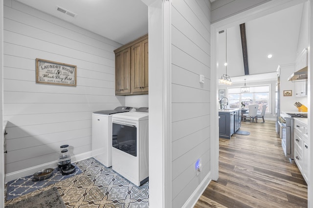 3745 Raulston Falls Rd, Jasper, TN 37347 - washroom with wood walls, separate washer and dryer, sink, cabinets, and dark wood-type flooring