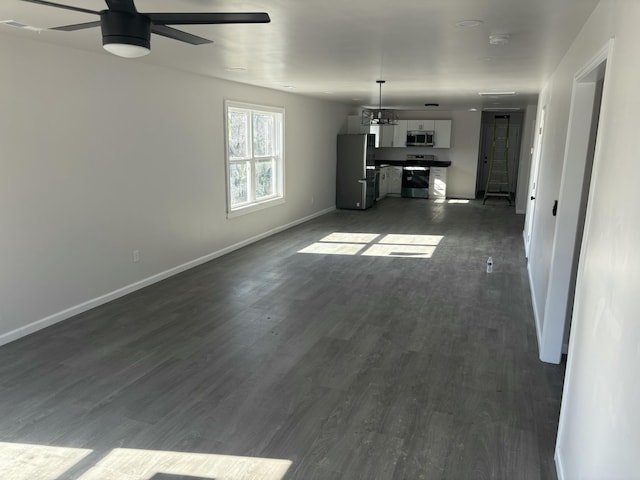 unfurnished living room with ceiling fan and dark hardwood / wood-style flooring