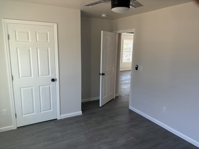 unfurnished bedroom with ceiling fan, dark hardwood / wood-style flooring, and a closet