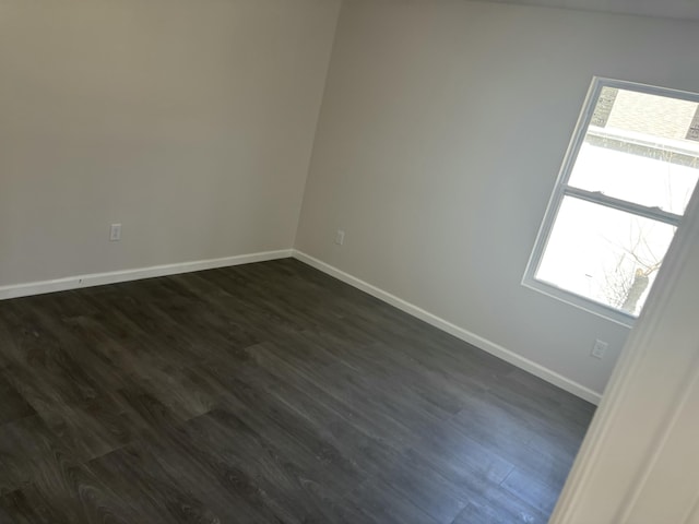 unfurnished room featuring a wealth of natural light and dark hardwood / wood-style flooring