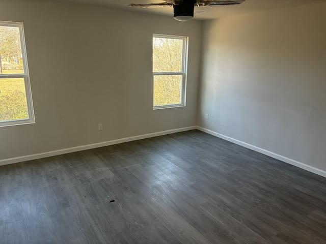 spare room featuring ceiling fan, dark wood-type flooring, and a wealth of natural light