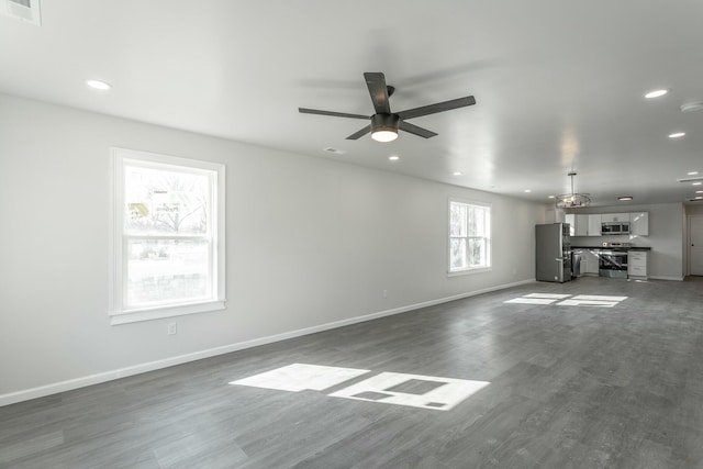 unfurnished living room with dark wood-type flooring and ceiling fan