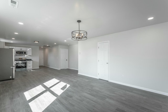 unfurnished living room with dark hardwood / wood-style flooring and a chandelier