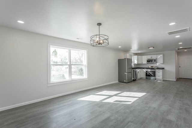 unfurnished living room with a chandelier and hardwood / wood-style flooring