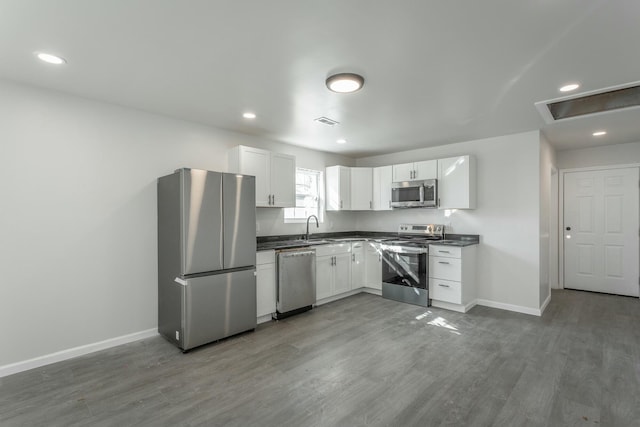 kitchen featuring sink, white cabinetry, dark hardwood / wood-style flooring, and stainless steel appliances