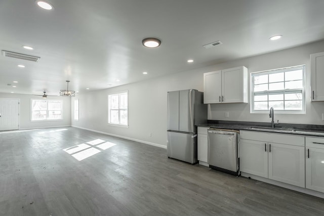 kitchen featuring ceiling fan, wood-type flooring, sink, appliances with stainless steel finishes, and white cabinets