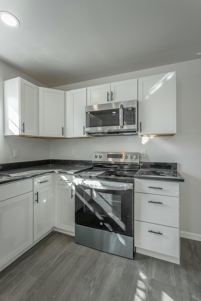 kitchen featuring dark hardwood / wood-style flooring, stainless steel appliances, and white cabinetry