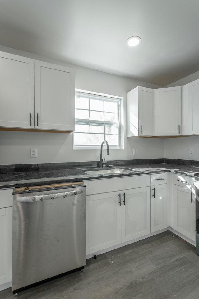 kitchen with stainless steel dishwasher, wood-type flooring, sink, white cabinetry, and range